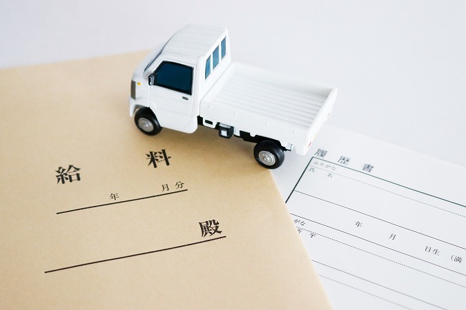 給料の封筒とトラックの模型